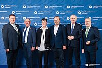 Impressionen von der Begrüßung der Gäste – Portraitaufnahmen vor einer blauen Fotowand