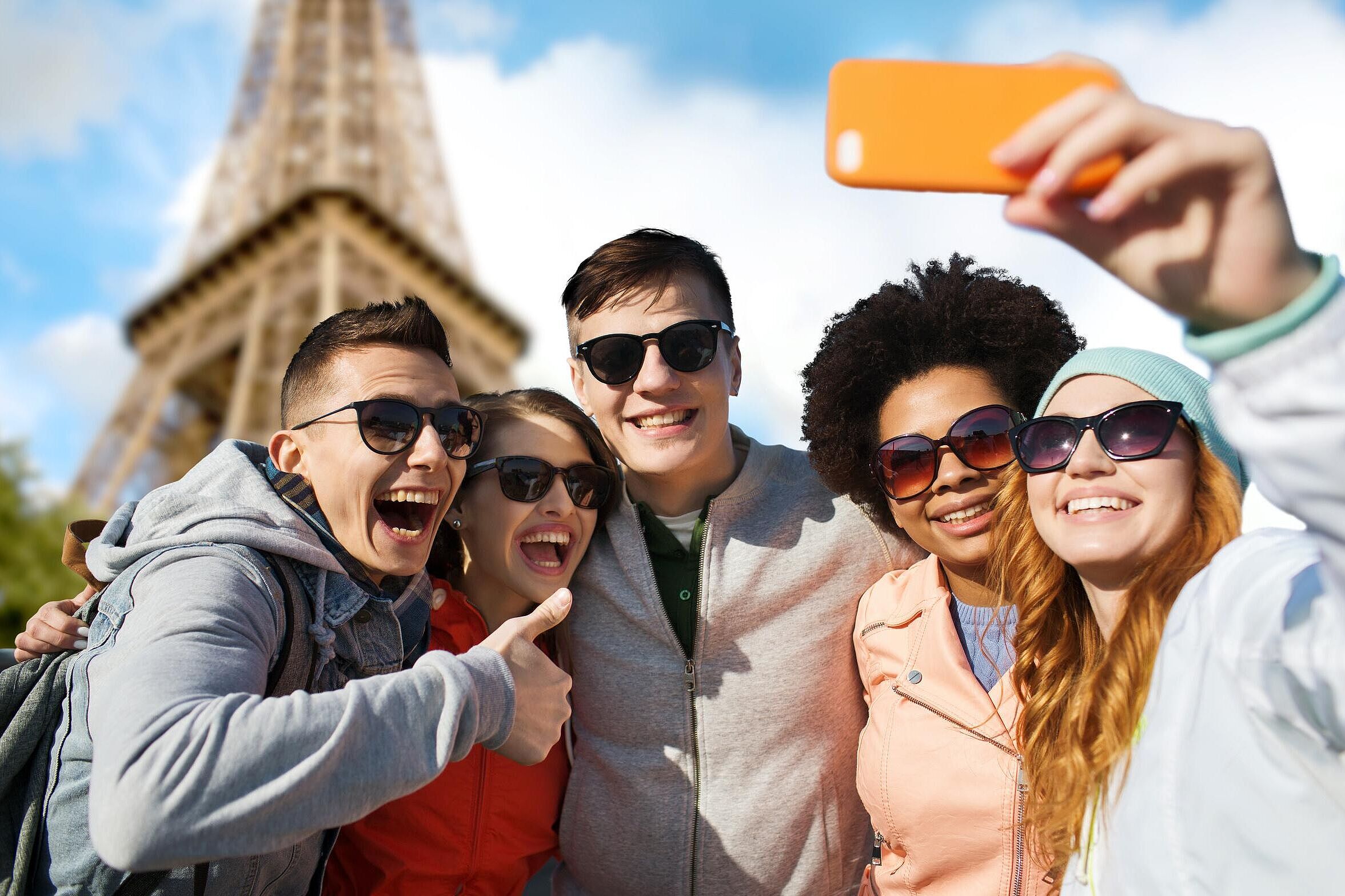 5 lächelnde Freunde mit Sonnenbrillen, die Selfie mit Smartphone machen, im Hintergrund der Eifelturm