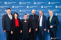 Impressionen von der Begrüßung der Gäste – Portraitaufnahmen vor einer blauen Fotowand