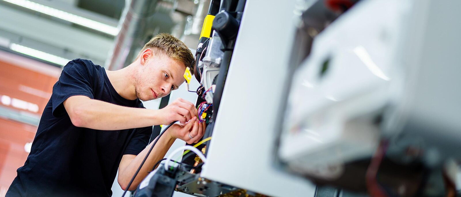 Eine Personen führt Reparaturen an einer Heizungsanlage/Boiler aus.