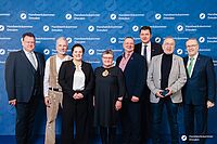 Impressionen von der Begrüßung der Gäste – Portraitaufnahmen vor einer blauen Fotowand