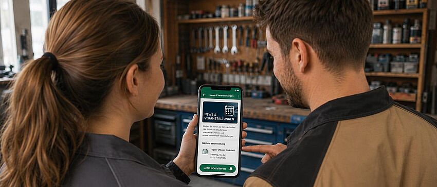 Zwei Personen betrachten ein geöffnetes WhatsApp-Fenster auf einem Handy.