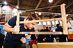 Zimmerer im ersten Ausbildungsjahr, arbeitet an einem Messestand mit einer Holzsäge an einer Seilhieb-Verzierung.