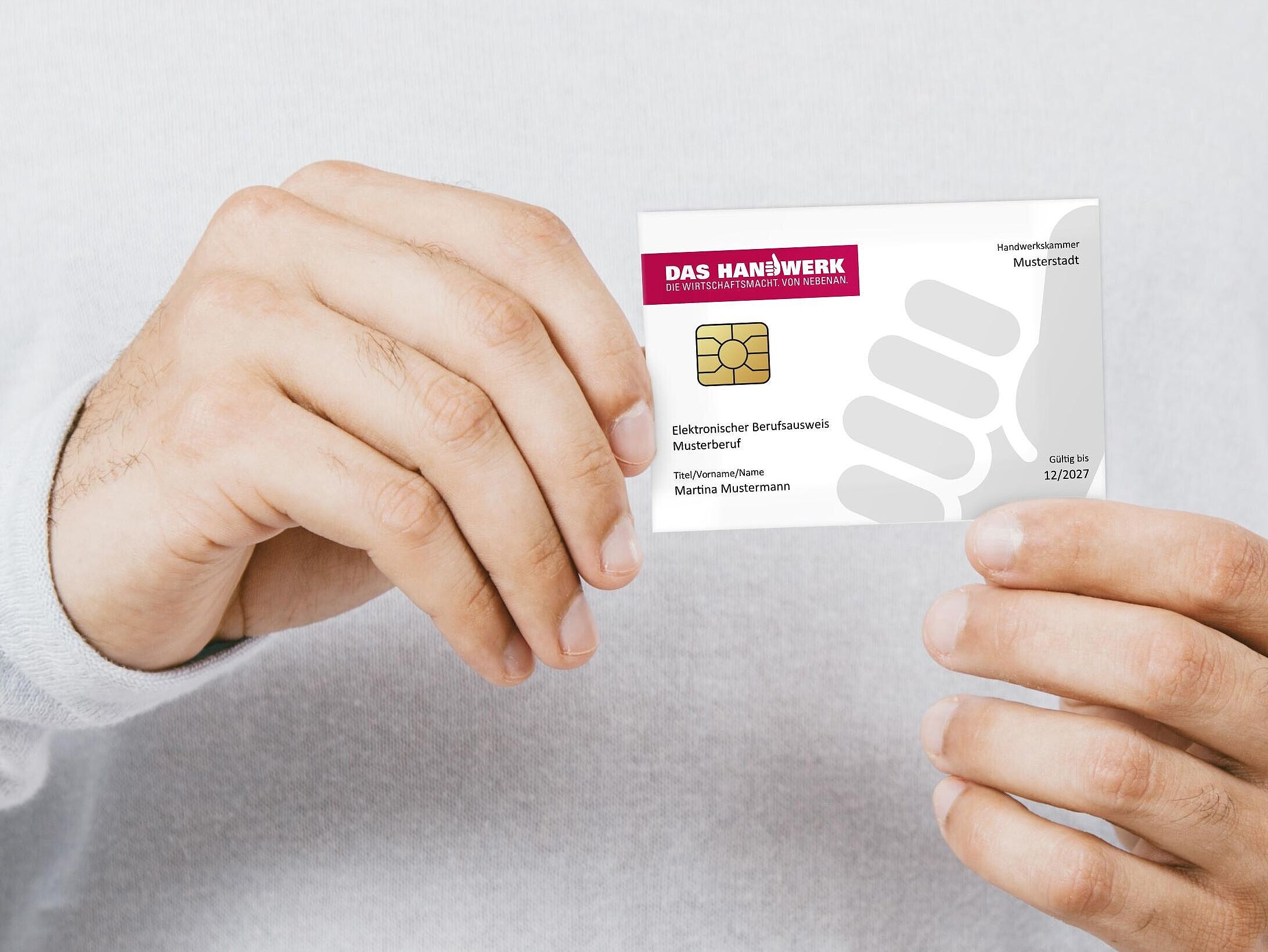 Eine Person hält eine Musterkarte des Elektronischer Berufsausweis (eBA) in den Händen.