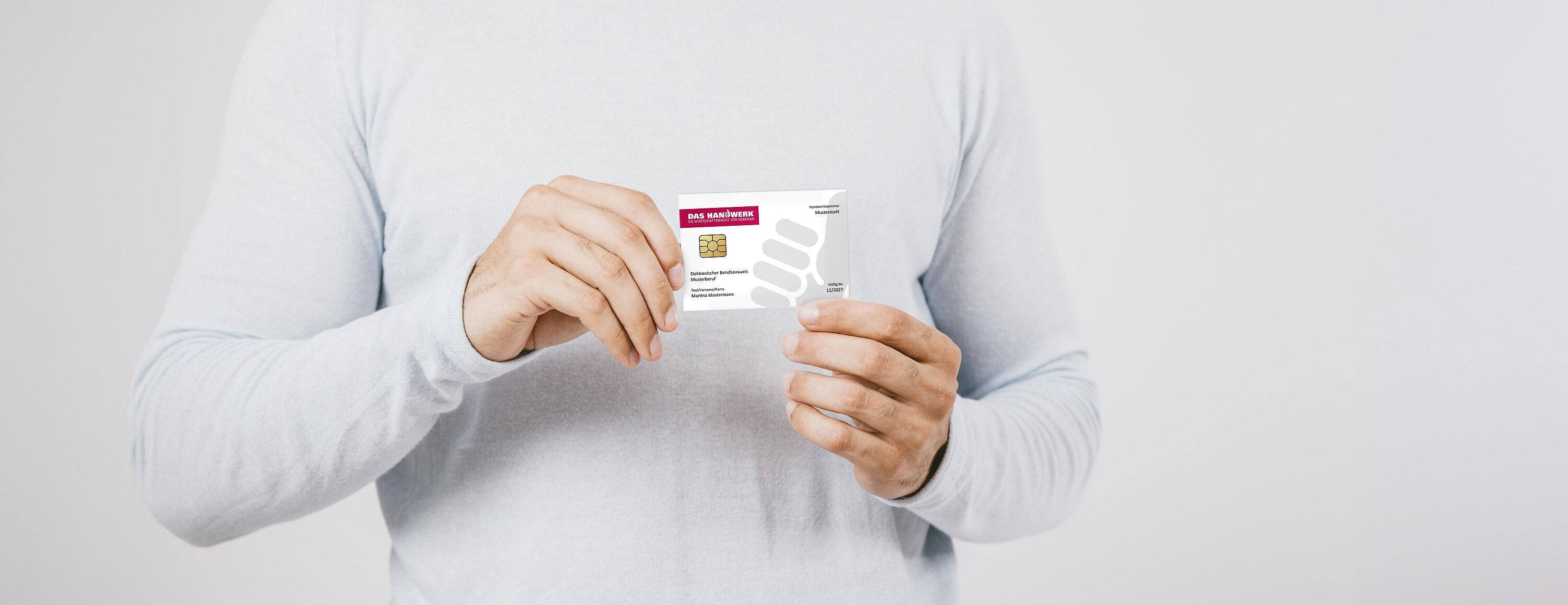 Eine Person hält eine Musterkarte des Elektronischer Berufsausweis (eBA) in den Händen.