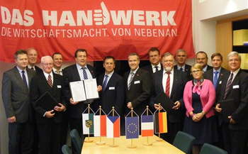 Gruppenfoto der Teilnehmer am Europaforum in Brüssel, in den Händen halten diese das Positionspapier  \"Erwartungen des Handwerks an eine zukunftsgewandte KMU-Politik in Europa\"