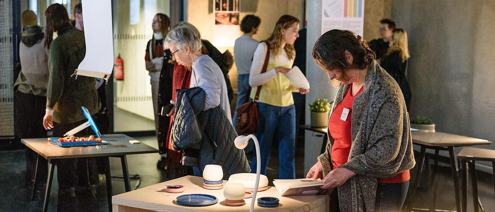 Handwerk trifft Design: ein Rundgang durch die Werkschau der Fakultät Design Mehrere Personen besuchen eine Ausstellung bzw. Werkschau der Fakultät Design