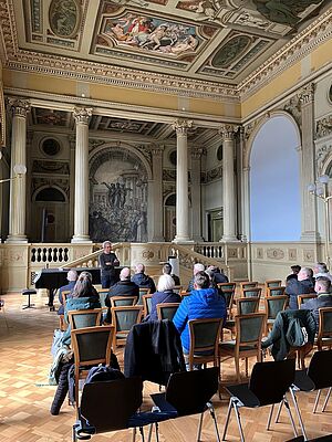 Restaurierung trifft Innovation: Handwerksbetriebe auf Messeerkundungsreise in Zürich Blick in den Tagungsssaal der Semperaula ETH mit interessiert zuhörenden Teilnehmern.
