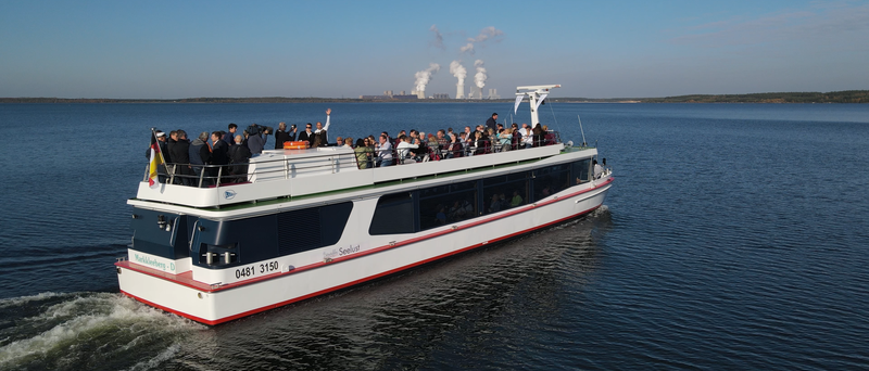 Blick von oben auf das Schiff „MS Bärwalder Seelust“, das gerade auf dem See fährt.