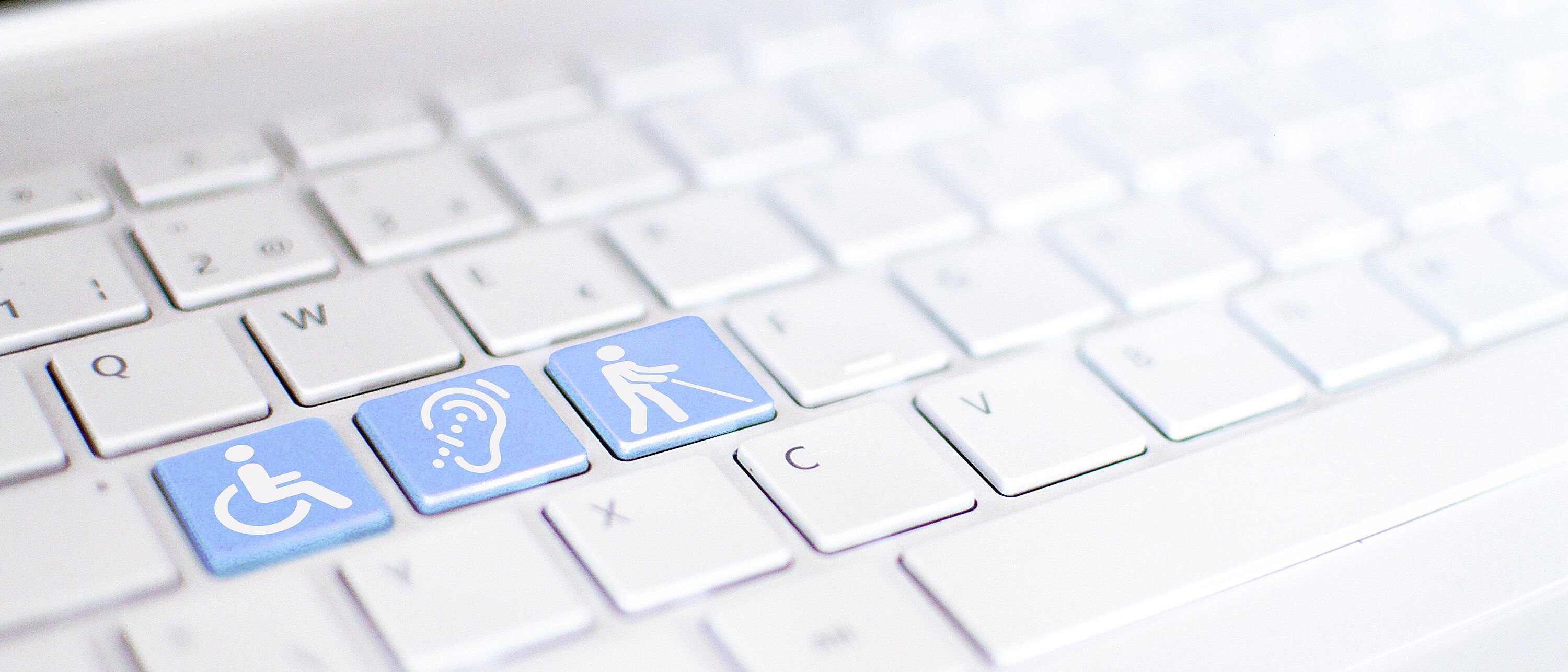 Bildmontage: Macroaufnahme von einer Tastatur, darauf drei blau hervorgehobene Tasten mit weißen Icons/Symbole eines Rollstuhl, gehörlos und taub.