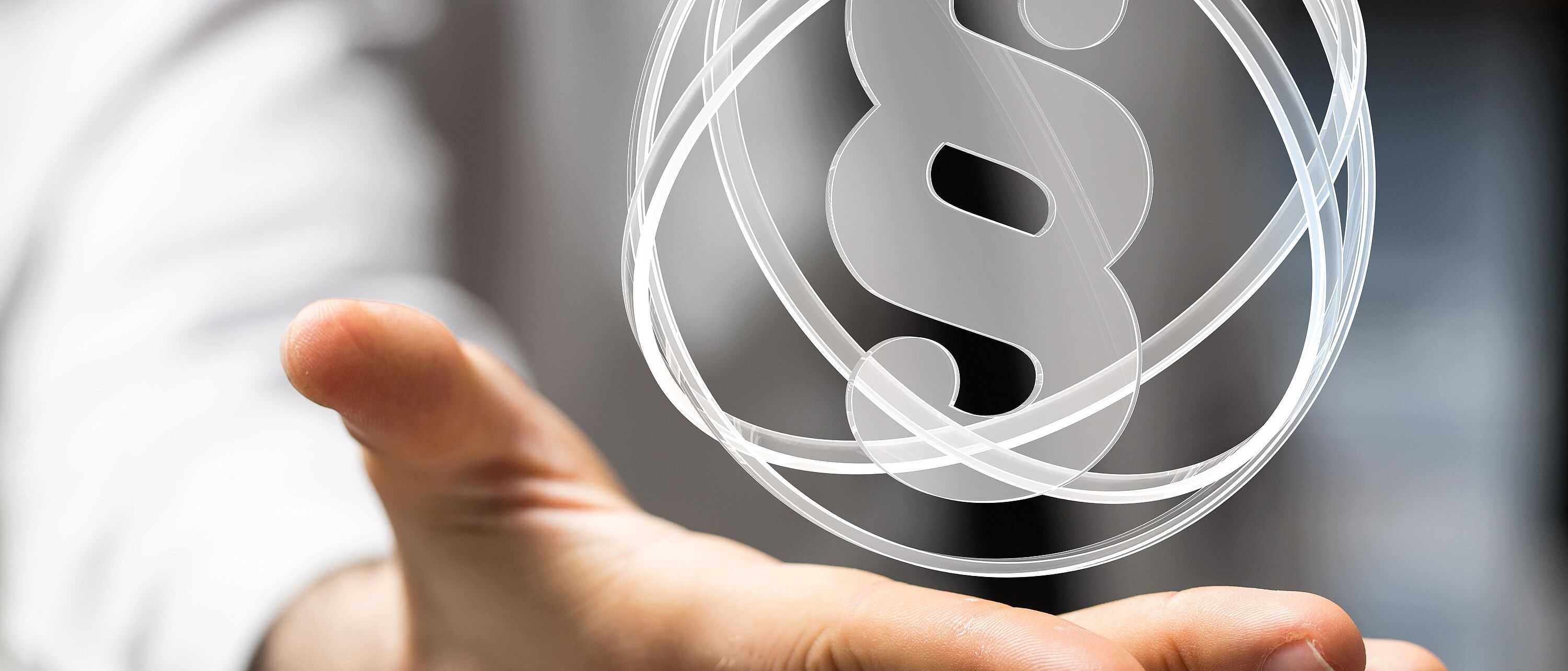 Rechtsberatung Eine waagerecht gehaltene Hand darauf steht ein grafisches Paragaphenzeichen.