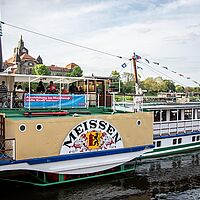 Ein Dampfschiff der sächsischen Elbflotte (Meißen) mit einem Werbebanner der Imagekampagne \"Ausbilden im Handwerk – volle Kraft voraus!\"