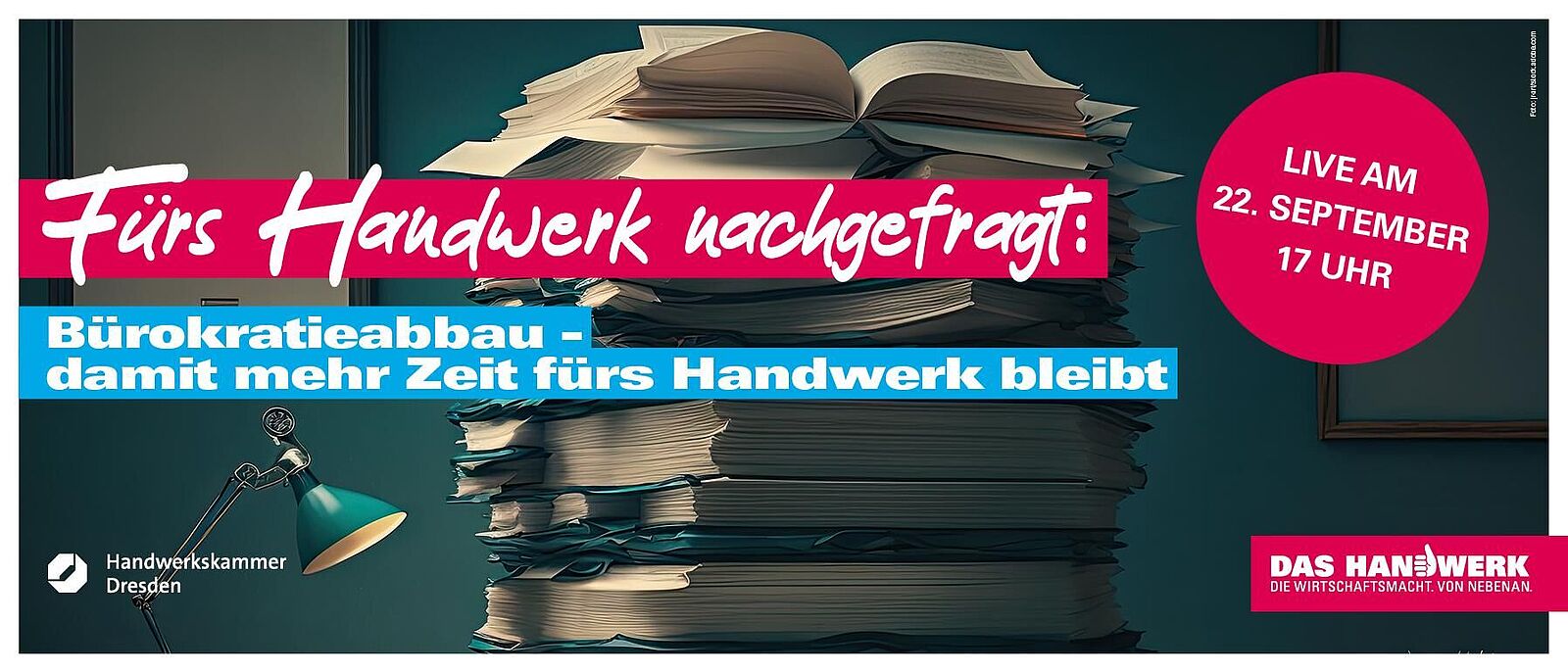 Ein Stapel Papierdokumente liegt auf einem Arbeitstisch im Büro. Darüber farbig der Schriftzug \"Fürs Handwerk nachgefragt: Bürokratieabbau – damit mehr Zeit für das Handwerk bleibt!