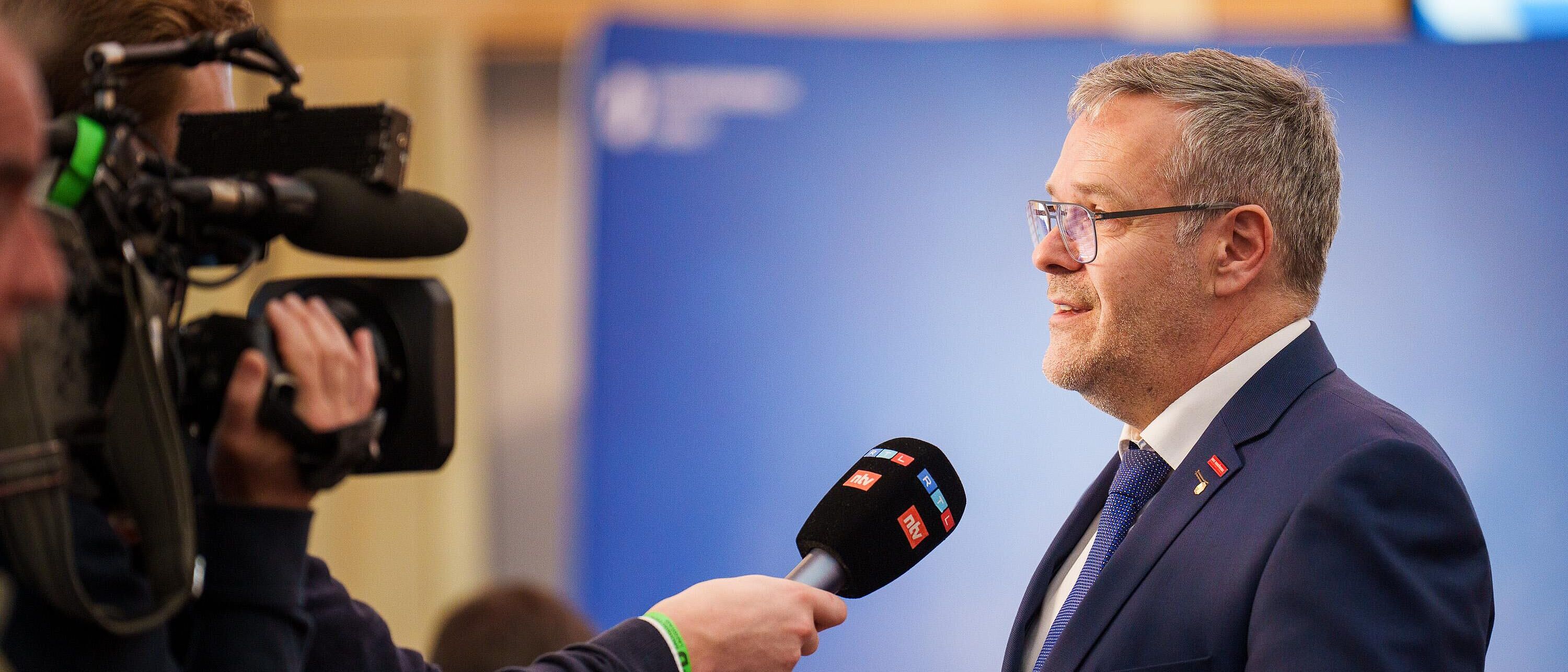 Handwerkskammerpräsident Jörg Dittrich steht rechts im Bild, ihm gegenüber ein Kamerateam von RTL denen er Fragen in ein bereitgehaltenes Mikrofon beantwortet.