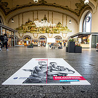 Auf einen Fliesenboden des Neustädter Bahnhofes wurde ein regionales Imagekampagnen-Motiv aufgebracht.