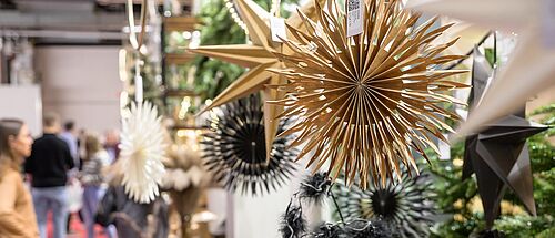 Messestand mit einer Makroaufnahme von Varianten eines Weihnachtssternes bzw. Weihnachtsschmuckes.